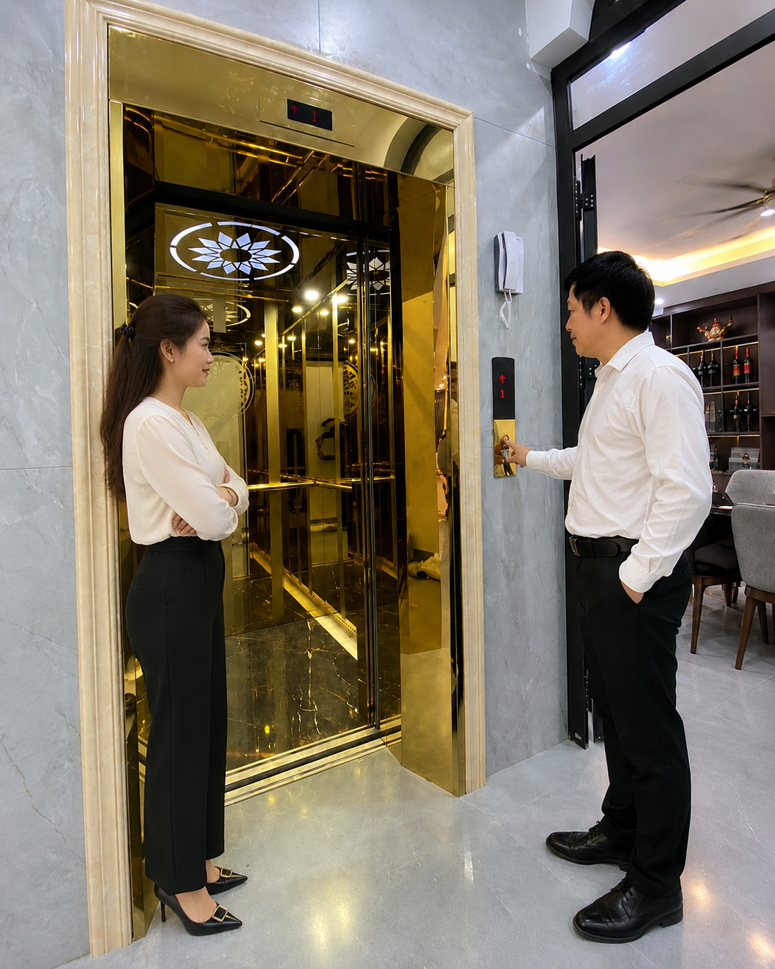 Thang máy gia đình cửa kính mạ vàng sang trọng với hai người đang chờ sử dụng